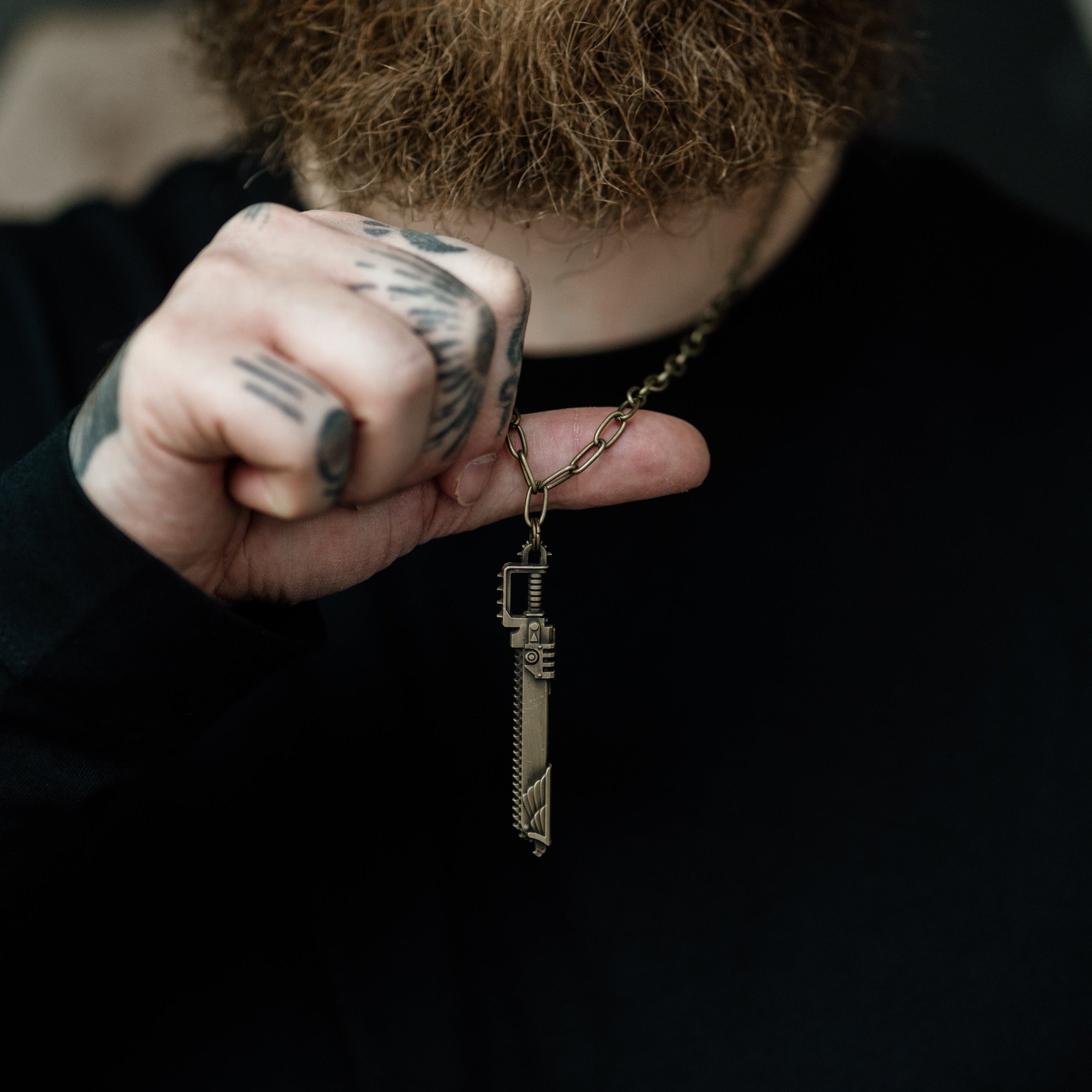 Person holding a key-shaped pendant with a blurred background