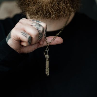 Person holding a key-shaped pendant with a blurred background