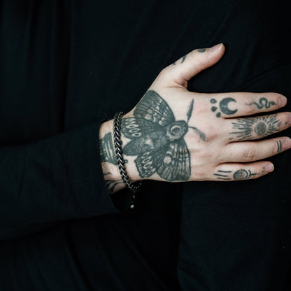 Hand with tattoos on a black background