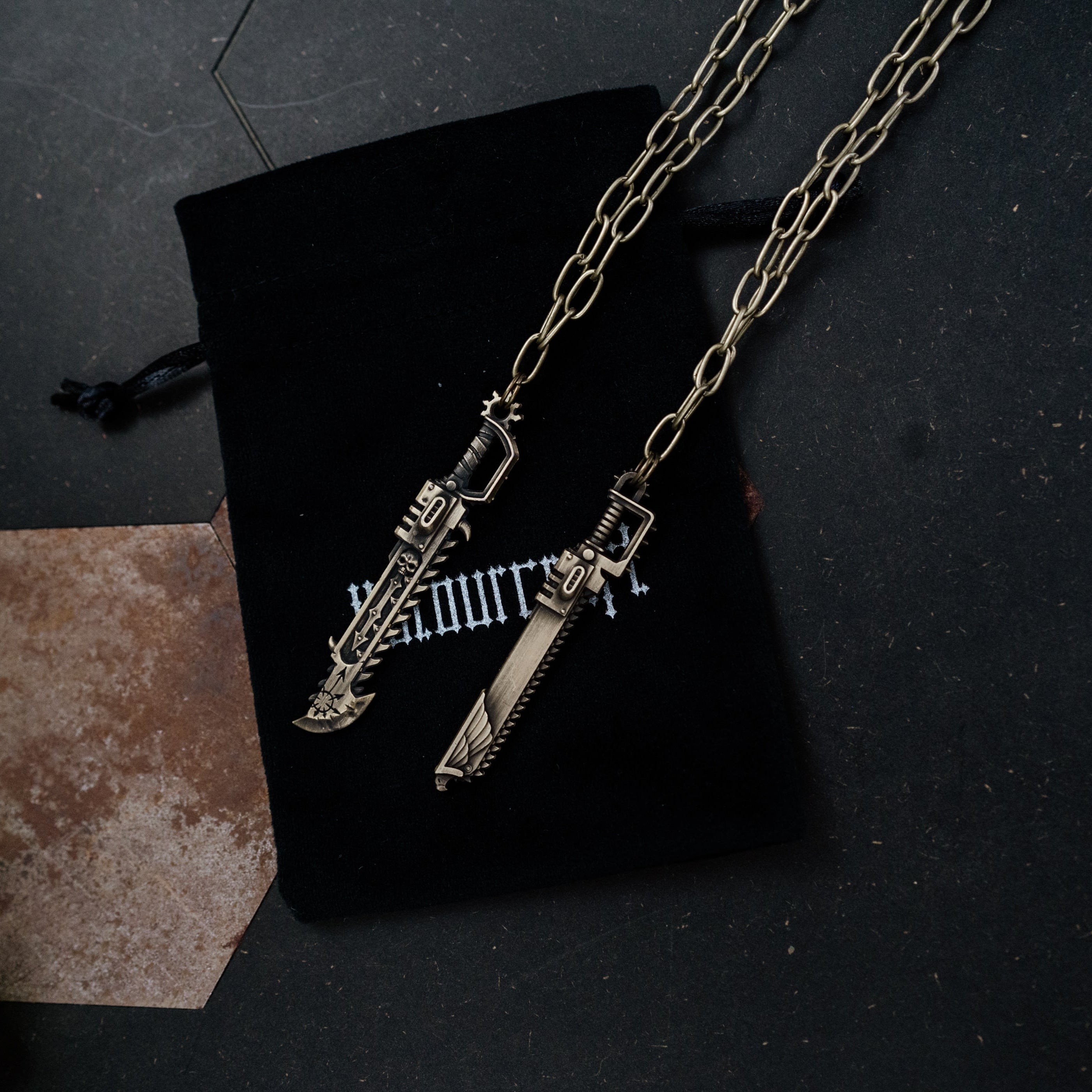 Necklace with guitar and microphone pendants on a black surface